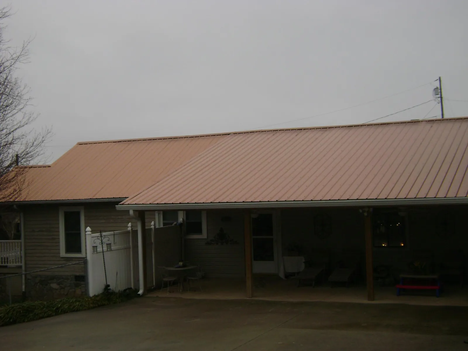 Copper toned metal roof over a wide covered patio in Broadway